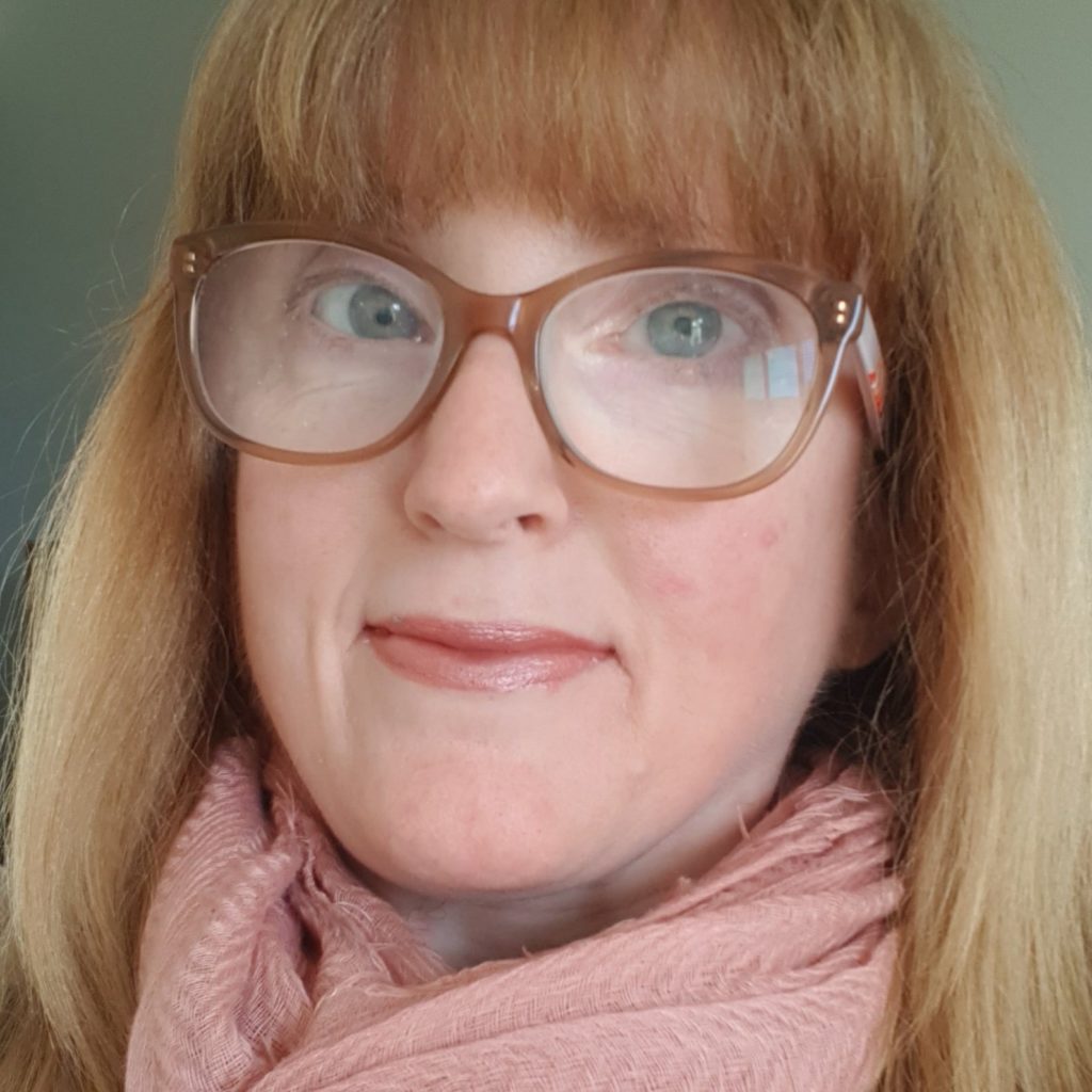 Ainslee wearing glasses and a scarf.