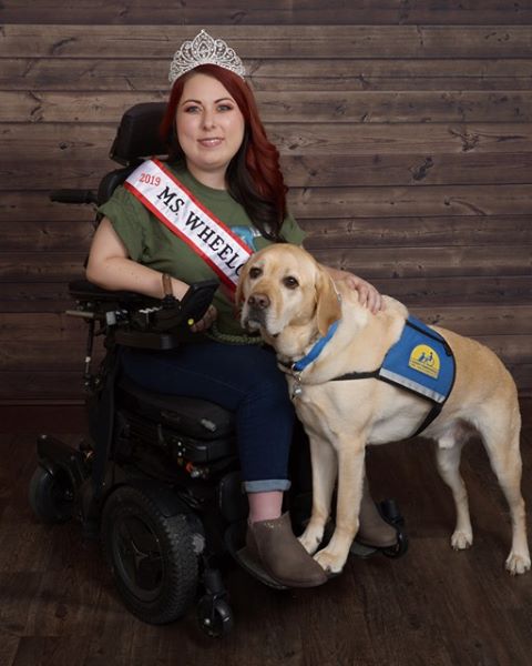 Lauren Taylor, Ms. Wheelchair Texas sitting in her wheelchair with her dog standing beside her. 